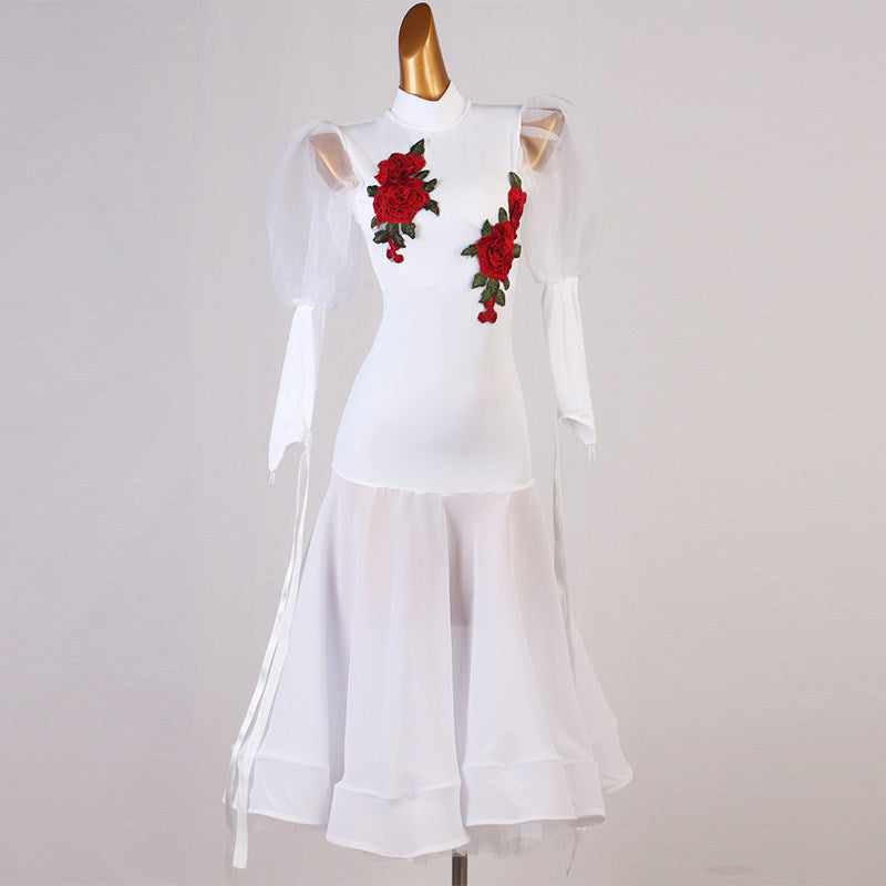 White ballroom dance dress with embroidered rose applique and mesh puff sleeves on mannequin