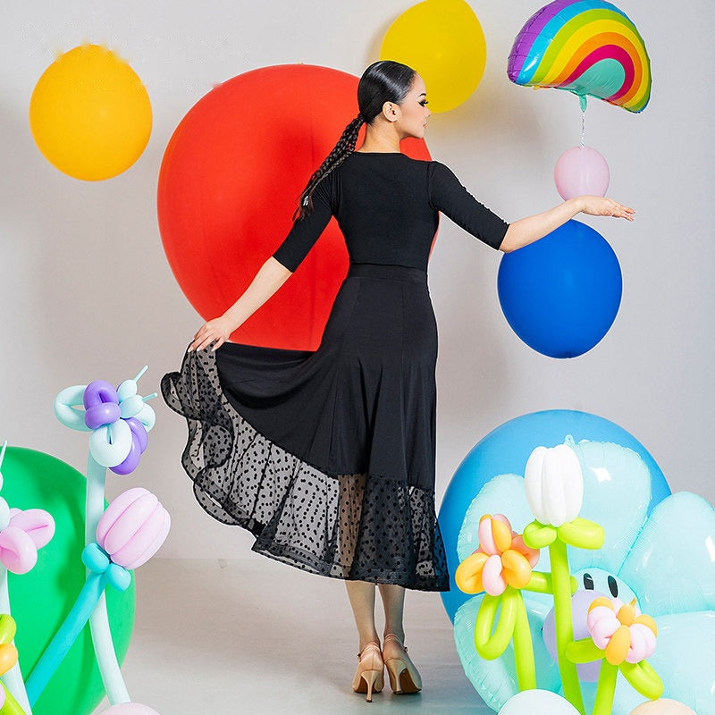 Back view of the black high waist ballroom skirt with the dotted mesh hem held out