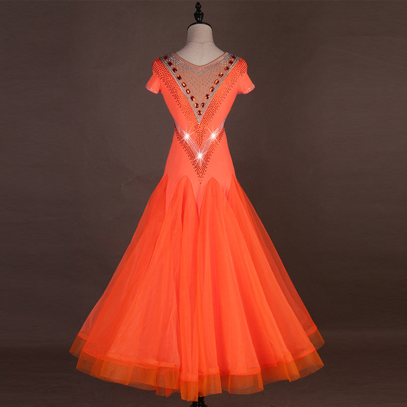 Orange ballroom competition dress showing stone V bodice and flared hem