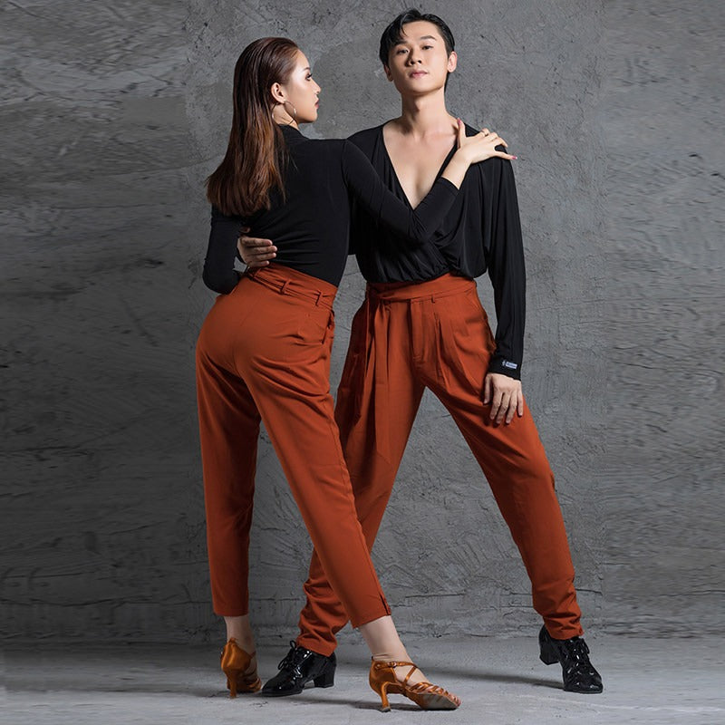 Rust tie belt dance pants worn by a Latin dance couple