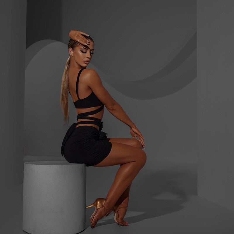 Black ruched rosette mini skirt, side view seated