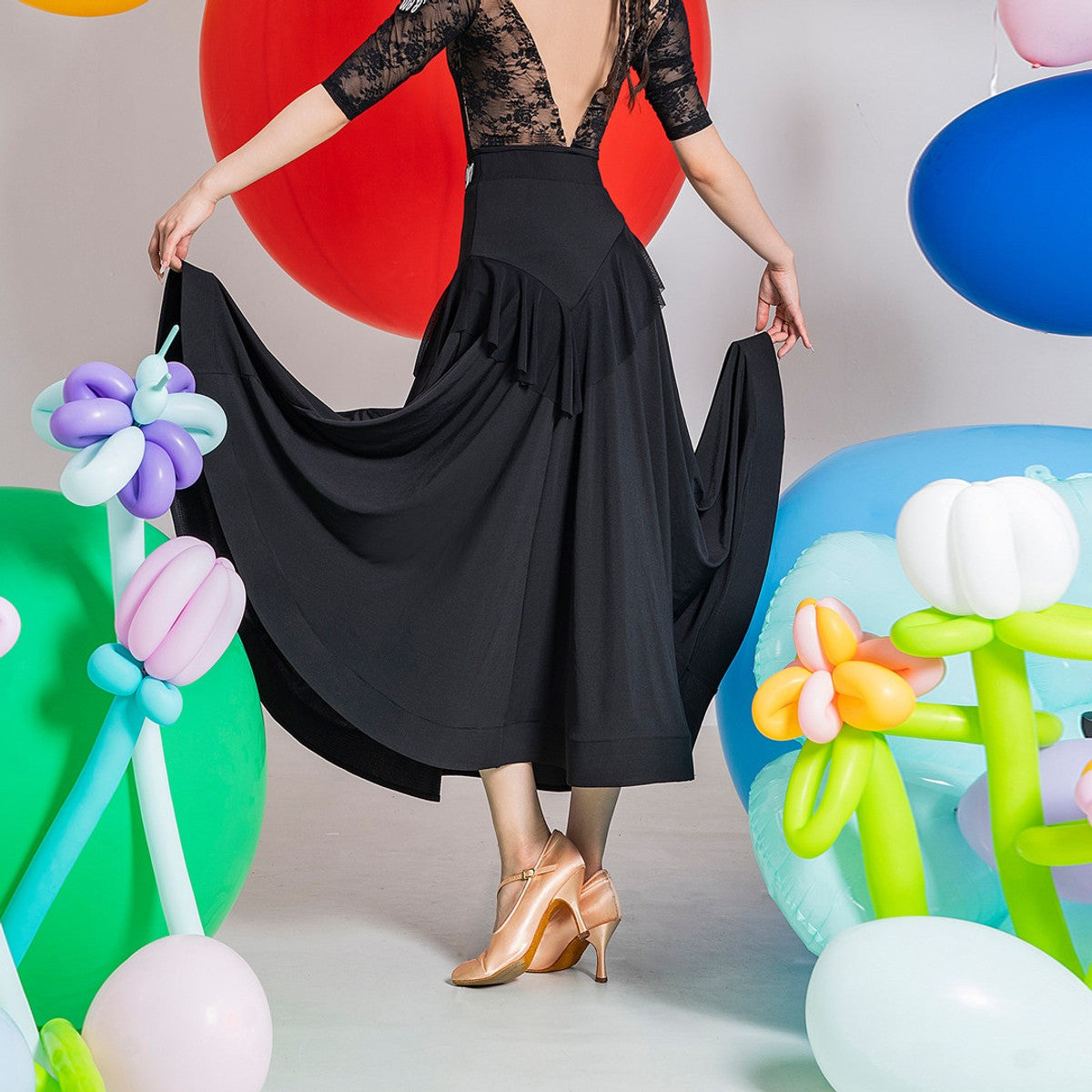 Black ballroom dance skirt, back view holding out the full circle hem