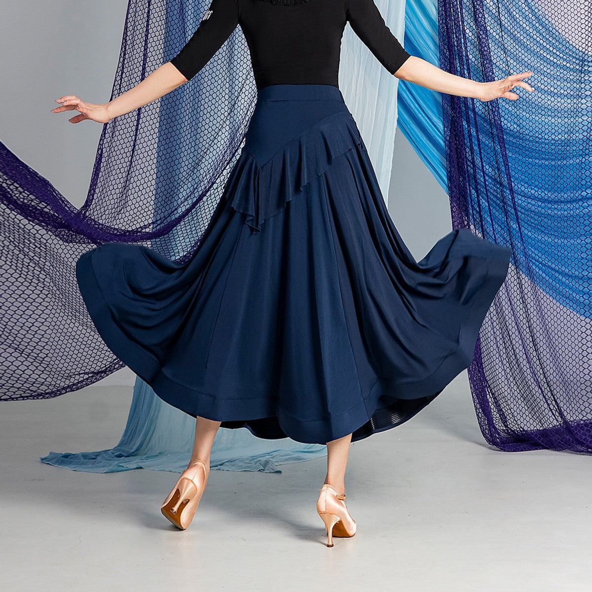 Navy ballroom dance skirt with high waist and front ruffle cascade, back view mid swing