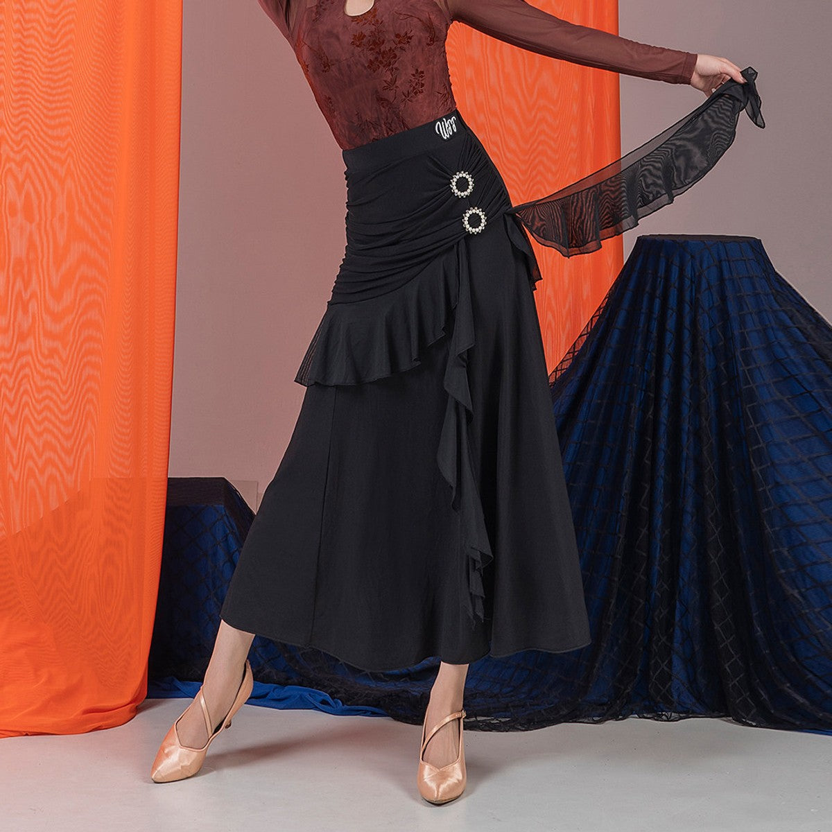 Black ballroom dance skirt with ruched panel, rhinestone buckles and mesh sash, front view