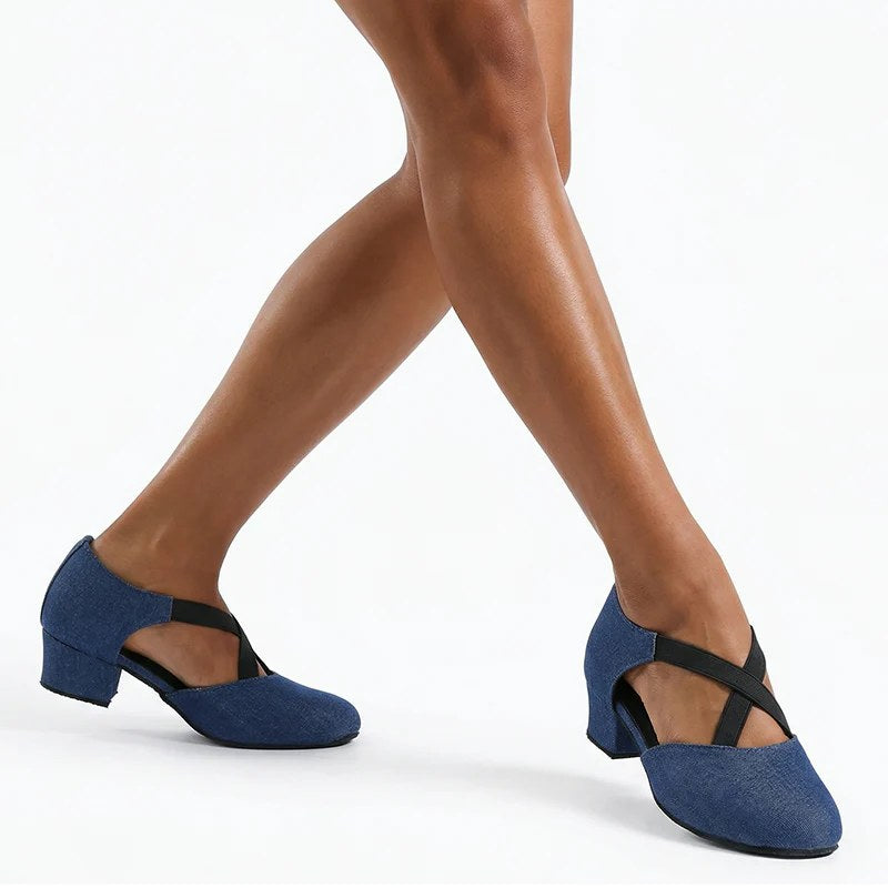 Woman wearing blue denim closed toe ballroom practice shoes, low block heel dance shoes with crossed elastic straps