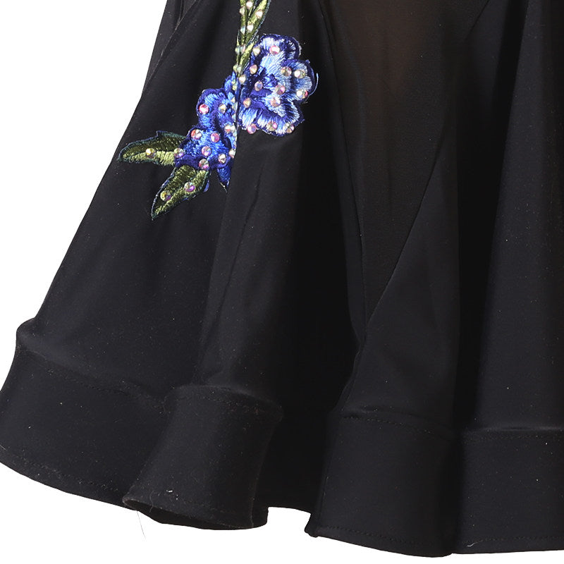 Close view of the fluted skirt hem under the sheer mesh body