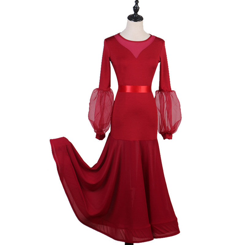 Red ballroom dress with mesh yoke and organza lantern sleeves, skirt sweeping to the side