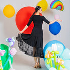 Back view of the black high waist ballroom skirt with the dotted mesh hem held out
