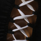Close up of the white ribbon lacing crossed through the open back panel