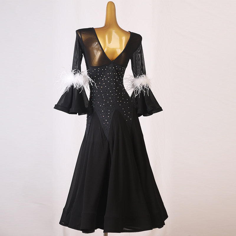 Back view of the black ballroom dress showing the low back and feather cuffs