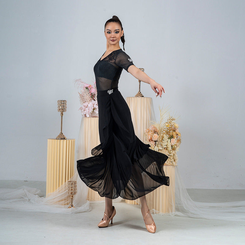 Close view of the layered wrap and mesh hem on the long black dance skirt