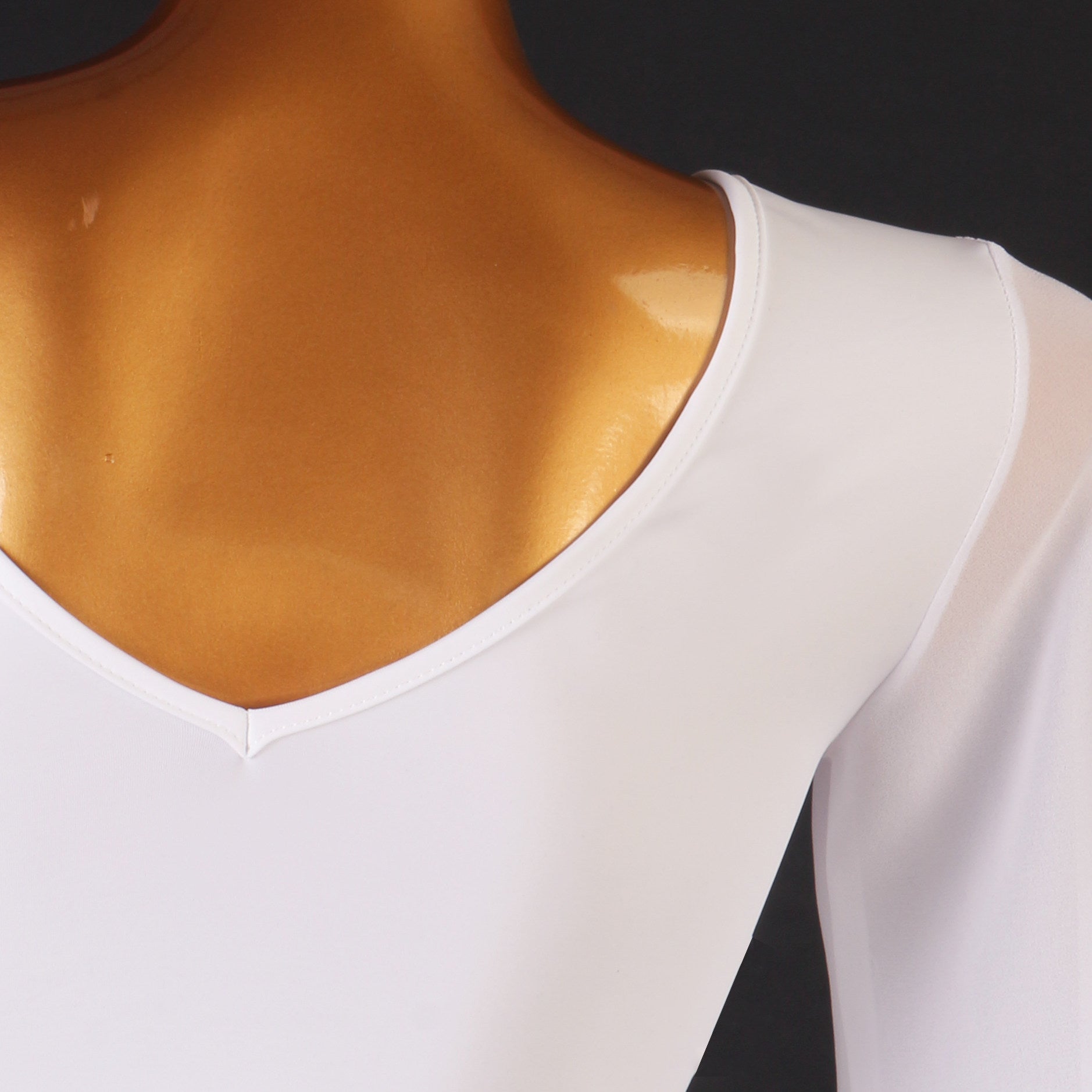 Close up of the deep V neckline on the white ballroom dance dress