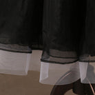 Hem detail showing the layered black tulle edge of the ballroom skirt