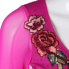 Close up of the embroidered rose and rhinestones on the fuchsia sleeve