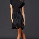 Black fringe Latin dance skirt worn with a black top, front view
