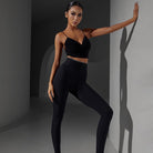 Black high waist Latin dance leggings, front view against the wall