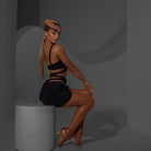 Black ruched rosette mini skirt, side view seated