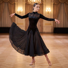 Black velvet ballroom dance dress with mesh shoulders and chevron skirt panels mid turn