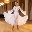 White ballroom dance dress with handkerchief flare sleeves held wide on a ballroom floor