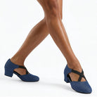 Woman wearing blue denim closed toe ballroom practice shoes, low block heel dance shoes with crossed elastic straps
