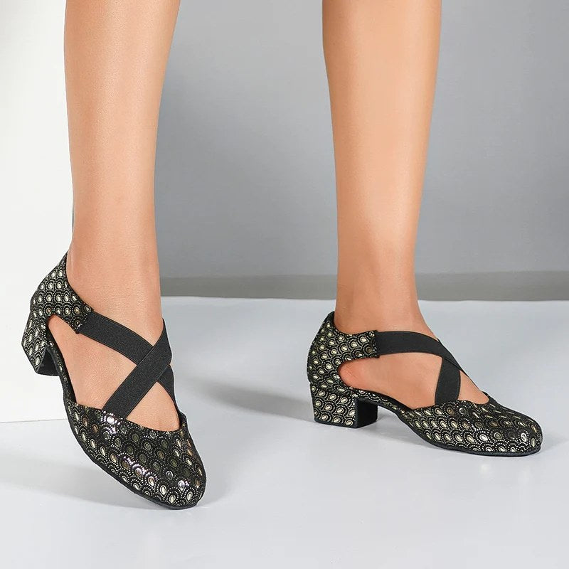 Woman wearing black metallic print closed toe ballroom practice shoes, low block heel dance shoes with crossed elastic straps