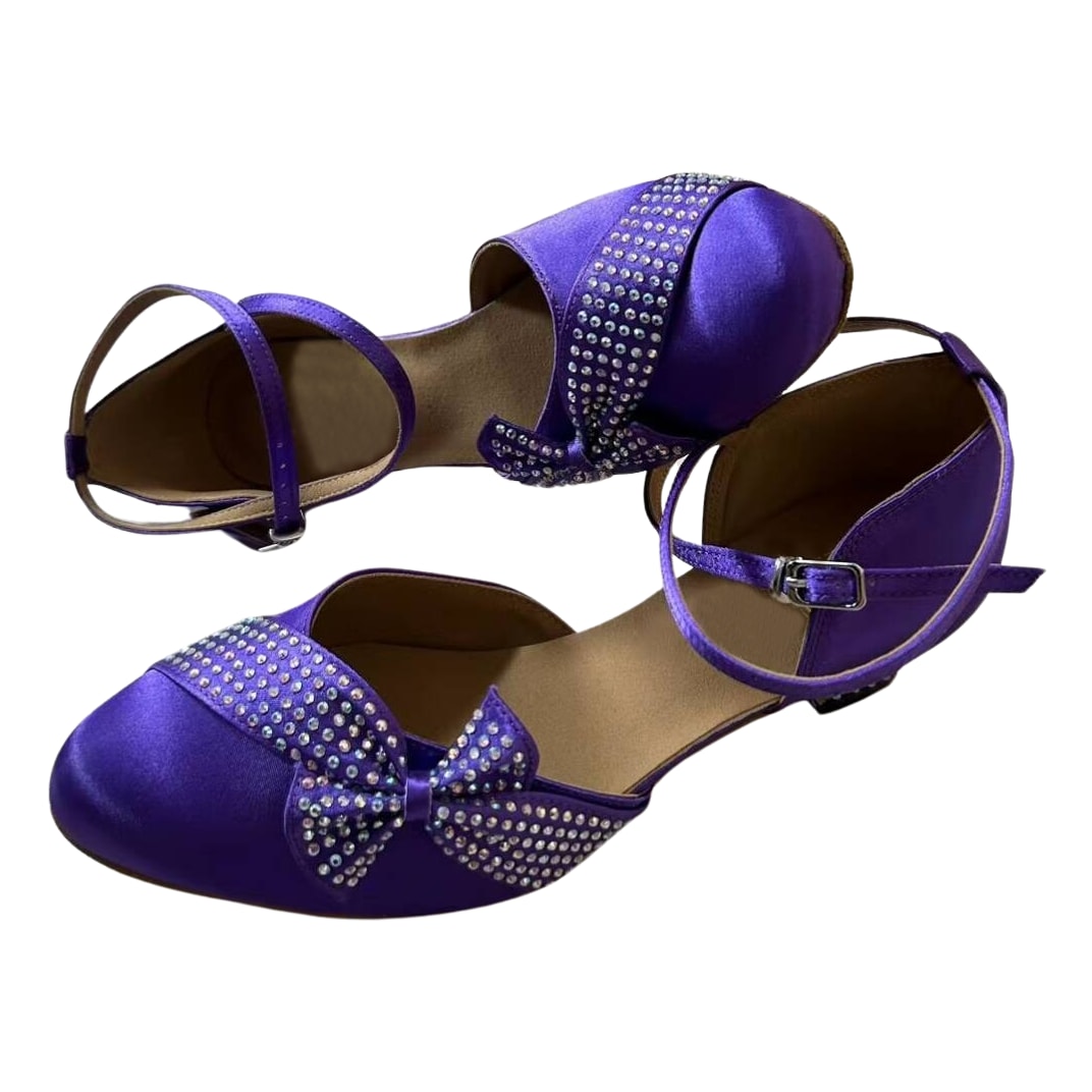 purple satin closed-toe ballroom dance shoes with rhinestone-trimmed bow and ankle strap