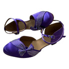 purple satin closed-toe ballroom dance shoes with rhinestone-trimmed bow and ankle strap