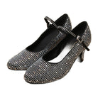 pair of black rhinestone-embellished ballroom dance shoes for women, closed-toe with ankle strap on wood floor