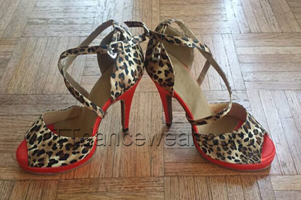 pair of leopard print samba platform dance heels for women with crossed ankle straps and a red platform sole