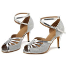 pair of silver glitter latin dance shoes for women with fanned metallic toe straps, crossed ankle straps and a stiletto heel