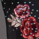 Close view of the raised rose embroidery ringed with rhinestones