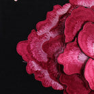 Close view of the layered fabric rose corsage