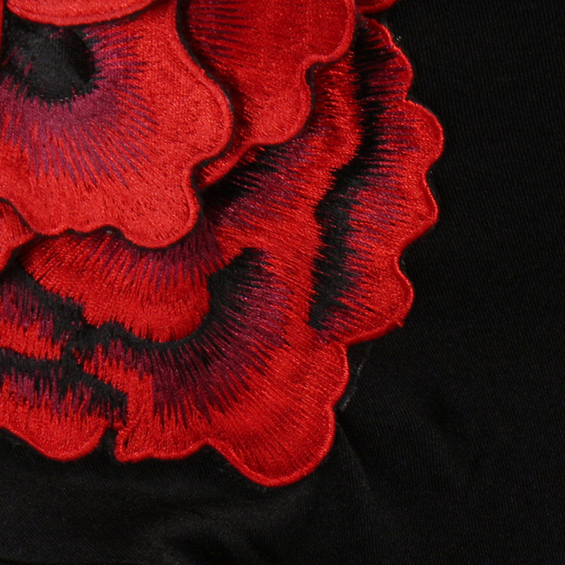 Close view of the layered red fabric rose at the hip