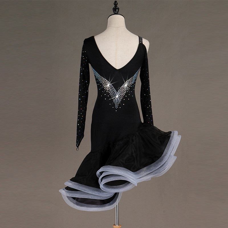 Black latin dance dress angled view showing the stoned mesh sleeves and grey ruffle edge