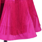 Close view of the finely pleated skirt and fringe edge