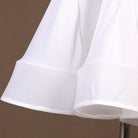 Close view of the white flared skirt hem