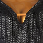 Close view of the bugle bead fringe hanging from the V neckline